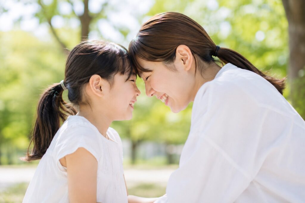 顔を寄せておでこをあわせて笑いあう親子